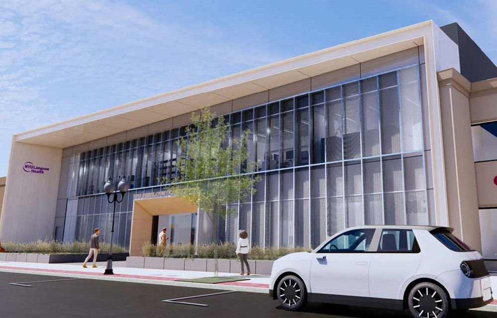 Photorealistic exterior rendering of the completed NYU Langone Patchogue Ambulatory Surgical Center, showing the two-story glass-and-metal healthcare facade and NYU Langone Health signage along the Patchogue streetscape.